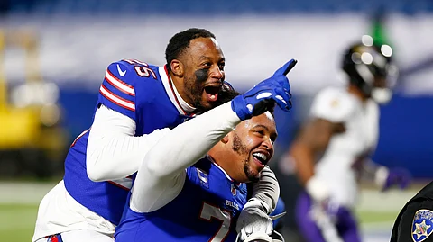 Buffalo Bills' Taiwan Jones (25) celebrates with Dion Dawkins (73) after an NFL divisional round football game against the Baltimore Ravens Saturday, Jan. 16, 2021, in Orchard Park, N.Y. The Bills won 17-3.
