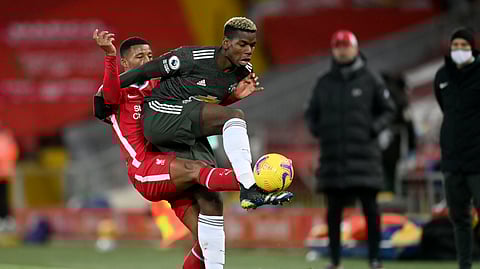 Liverpool's Georginio Wijnaldum, left, vies for the ball with Manchester United's Paul Pogba during the English Premier League soccer match between Liverpool and Manchester United at Anfield Stadium, Liverpool, England, Sunday, Jan. 17, 2021.