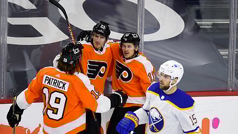Philadelphia Flyers' Travis Konecny, second from right, celebrates with Oskar Lindblom (23) and Nolan Patrick after Konecny scored a goal past Buffalo Sabres goaltender Carter Hutton during the second period of an NHL hockey game, Tuesday, Jan. 19, 2021, in Philadelphia.