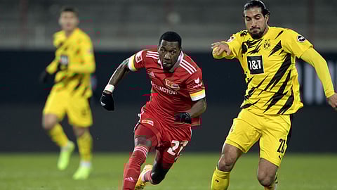 Union's Sheraldo Becker, left, in action against Dortmund's Emre Can during the German Bundesliga soccer match between 1. FC Union Berlin and Borussia Dortmund at the Stadion Alte Forsterei in Berlin, Friday, Dec. 18, 2020.
