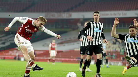 Arsenal's Emile Smith Rowe, left, scores the opening goal during the English FA Cup third round soccer match between Arsenal and Newcastle United at the Emirates Stadium in London, England, Saturday, Jan. 9, 2020.