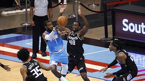 Houston Rockets guard John Wall passes the ball around Sacramento Kings' Harrison Barnes during the first half of an NBA basketball game Thursday, Dec. 31, 2020, in Houston.