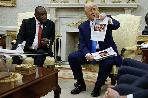 US President Donald Trump holds up a printed article while accusing South Africa President Cyril Ramaphosa of state-sanctioned violence against white farmers in South Africa at the White House in Washington, DC on May 21.