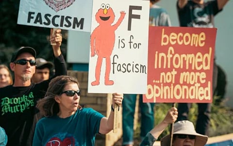 People hold anti-fascist signs at a protest. In Trump’s America, they have been designated “terrorists”.