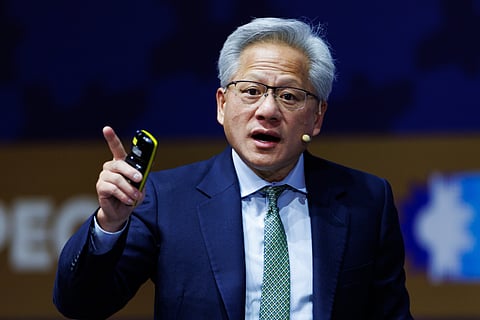 Nvidia CEO Jensen Huang mic'd up with a clicker in hand delivering a keynote on stage.