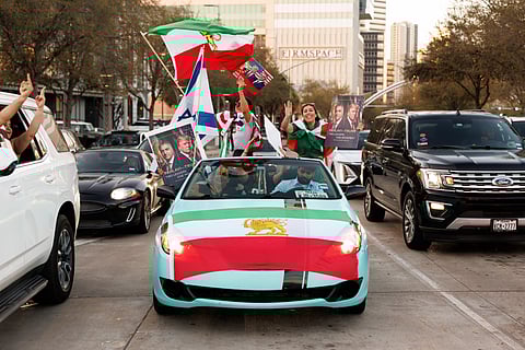 (EDITOR'S NOTE: Image contains profanity) Counter-demonstrators drive past a protest against war in Iran in Houston, Texas, US, on Saturday, Feb. 28, 2026.