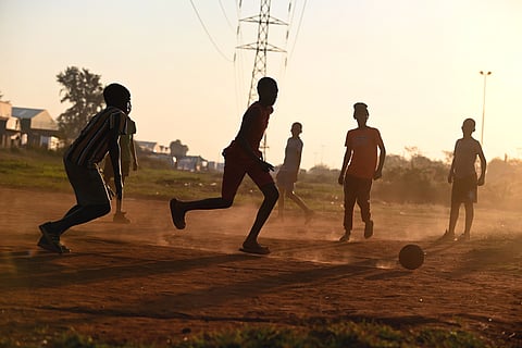 Children play football on a dirt clearing in the Slovo Park informal settlement outside Johannesburg
