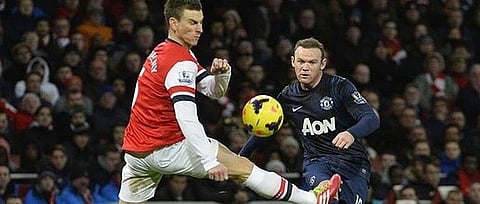 Wayne Rooney is challenged by Arsenal's Laurent Koscielny