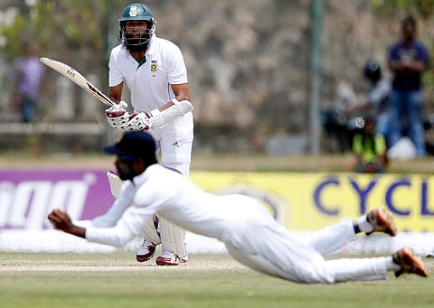 South Africa's captain Hashim Amla watches as he caught out by Sri Lanka's Upul Tharanga (bottom) during the fourth day of their first test cricket match in Galle July 19, 2014. REUTERS/Dinuka Liyanawatte