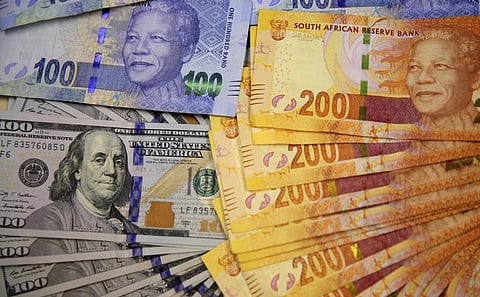 South African bank notes featuring images of former South African President Nelson Mandela (R) are displayed next to the American dollar notes in this photo illustration in Johannesburg August 13 2014. REUTERS/Siphiwe Sibeko