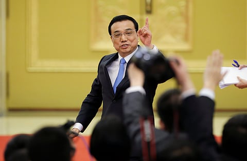China's Premier Li Keqiang gestures to the media as he leaves after the annual news conference following the closing session of the National People's Congress (NPC), or parliament, at the Great Hall of the People in Beijing March 15, 2015. China faces financial dangers as its economy cools but authorities can prevent systemic risks, Li said on Sunday. REUTERS/Jason Lee