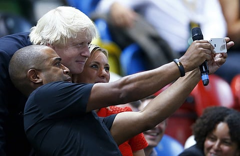 London mayor Boris Johnson poses for a selfie with two venue presenters as he attends the wheelchair rugby semi-final between Great Britain and Australia at the Invictus Games at the Olympic Park in east London, in this September 12, 2014 file photo.   REUTERS/Andrew Winning
