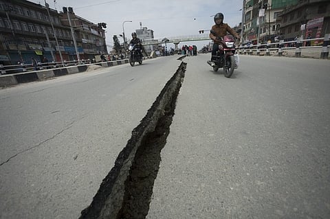 Motorcyclists use both sides of a wide crack in the Koteshwor-Suryabinayak Highway caused by the earthquake in the Bhaktapur area near Kathmandu, Nepal on 26 April, 2015 -- twenty four hours after a devastating quake which so far has taken the lives of at least 3 000. EPA/Hemanta Shrestha