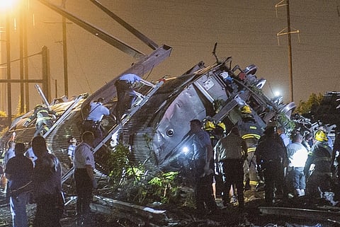Rescue workers search for victims in the wreckage of a derailed Amtrak train in Philadelphia, Pennsylvania May 12, 2015. An Amtrak passenger train with more than 200 passengers on board derailed in north Philadelphia on Tuesday night, killing at least five people and injuring more than 50 others, several of them critically, authorities said. Authorities said they had no idea what caused the train wreck, which left some demolished rail cars strewn upside down and on their sides in the city's Port Richmond neighborhood along the Delaware River. REUTERS/Bryan Woolston