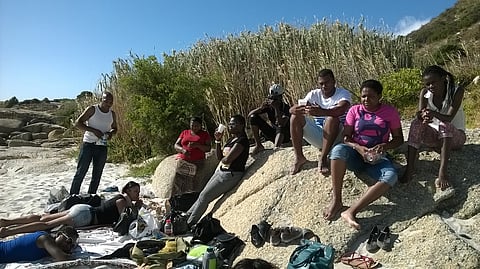 Veronica Tima on the beach with some of the students