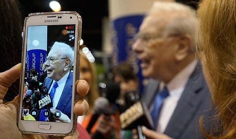 Berkshire Hathaway CEO Warren Buffett is seen on a cellphone camera as he talks to reporters prior to the Berkshire annual meeting in Omaha, Nebraska May 2, 2015. REUTERS/Rick Wilking