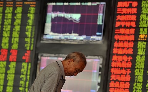 An investor looks down in front of an electronic board showing stock information at a brokerage house in Fuyang, Anhui province, China, June 29, 2015. China stocks ended an extremely volatile session down more than 3 percent on Monday, as investors shrugged off fresh monetary easing and dumped shares in panic. REUTERS/Stringer CHINA OUT. NO COMMERCIAL OR EDITORIAL SALES IN CHINA
