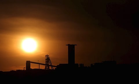 The sun sets behind a shaft outside the mining town of Carletonville, west of Johannesburg, July 7 2015. South African gold producers said on Tuesday that union wage demands were "unaffordable" and could add 16.5 billion rand ($1.3 billion) to the sector's wage bill.The producers, which include AngloGold Ashanti, Sibanye Gold and Harmony Gold, said in a statement that the industry's total wage bill in 2014 was 23.5 billion rand. REUTERS/Siphiwe Sibeko