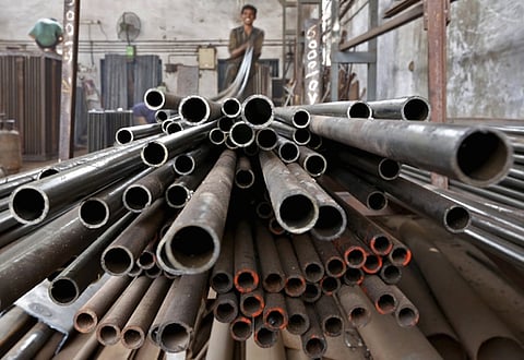 A worker stacks steel pipes in the western Indian city of Ahmedabad in this November 4, 2014 file photo. Any nuclear deal between Iran and six world powers loosening sanctions against Tehran could flood an oversupplied oil market with more fuel, yet sectors like cement and steel would see a rise in demand as the country works to revitalise its economy. Officials involved in ongoing negotiations said on Sunday they were close to a deal that would bring sanctions relief in exchange for curbs to Tehran's atomic programme, although no agreement was expected before July 13, 2015.  REUTERS/Amit Dave/Files