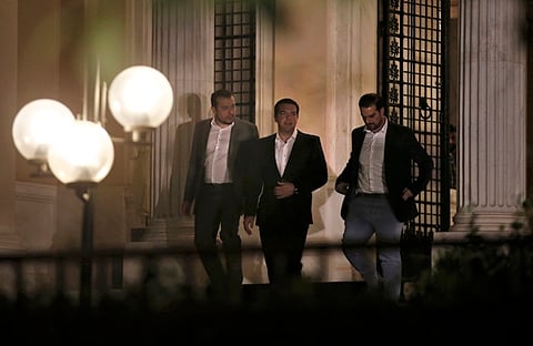 Greek Prime Minister Alexis Tspiras (C), accompanied by security agents, leaves his offices in Athens, Greece July 5, 2015. Greeks voted overwhelmingly "No" on Sunday in a historic bailout referendum, partial results showed, defying warnings from across Europe that rejecting new austerity terms for fresh financial aid would set their country on a path out of the euro. REUTERS/Jean-Paul Pelisser