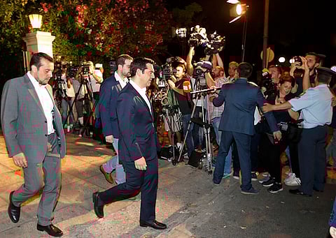 Greek Prime Minister Alexis Tspiras (C), accompanied by security agents, leaves his offices to walk to meet Greece's President Prokopis Pavlopoulios in Athens, Greece July 5, 2015. Greeks voted overwhelmingly "No" on Sunday in a historic bailout referendum, partial results showed, defying warnings from across Europe that rejecting new austerity terms for fresh financial aid would set their country on a path out of the euro. REUTERS/Jean-Paul Pelisser