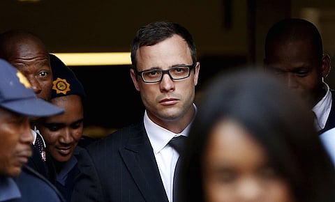 Paralympic track star Oscar Pistorius (C) leaves after listening to the closing arguments in his murder trial at the high court in Pretoria in this August 7, 2014 file photo. Pistorius is due to be released on Friday after serving 10 months of a five-year sentence, in line with South Africa's custodial guidelines for non-dangerous prisoners.   REUTERS/Siphiwe Sibeko/Files