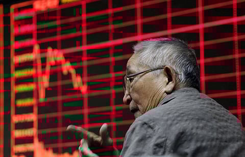 An investor chats in front of an electronic board showing stock information at a brokerage house in Beijing, August 26, 2015. Asian shares struggled on Wednesday as investors feared fresh rate cuts in China would not be enough to stabilise its slowing economy or halt a stock collapse that is wreaking havoc in global markets. REUTERS/Jason Lee