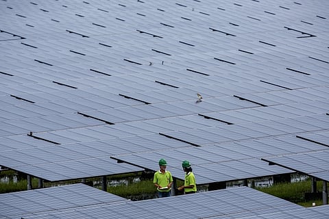 Employees of a solar farm company take notes between panels at the farm in Nakorn Ratchasima province, Thailand, October 3, 2013. Come December, Thailand will have more solar power capacity than all of Southeast Asia combined as record sums of money is poured into the sector in the hopes of nurturing a new energy source to help drive the region's second-biggest economy. To match story THAILAND-SOLAR/   Picture taken October 3, 2013. REUTERS/Athit Perawongmetha