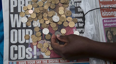 A newspaper vendor counts out change for a customer in Durban, September 8, 2015. REUTERS/Rogan Ward