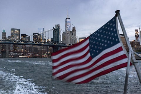 The Lower Manhattan skyline, One World Trade Center and Manhattan Bridge are seen in the background as a ferry with a U.S. flag cruises along the East River while carrying passengers (not pictured) to the 2016 Volkswagen Passat reveal in New York September 21, 2015. REUTERS/Darren Ornitz