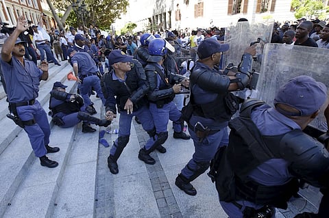 Police clash with students outside South Africa's Parliament in Cape Town, October 21, 2015. Riot police fired tear gas and stun grenades on Wednesday at hundreds of protesting students who stormed the parliament precinct in Cape Town to try to disrupt the reading of Finance Minister Nhlanhla Nene's interim budget. REUTERS/Mark Wessels