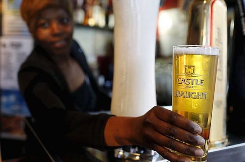 A bartender serves a beer produced by brewing company SAB Miller at a bar in Cape Town, September 16, 2015. SABMiller has rejected Anheuser-Busch InBev's approach about a takeover that would form a brewing colossus producing a third of the world's beer. A merged group would have a market value of around $275 billion (£177 billion) at current prices, and would combine AB InBev's dominance of Latin America with SABMiller's dominance in Africa, both fast-growing markets, as well as their breweries in Asia. REUTERS/Mike Hutchings