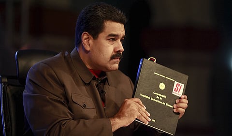 Venezuela's President Nicolas Maduro holds a copy of the country's constitution as he speaks during his weekly broadcast "In contact with Maduro" in Caracas in this handout picture provided by Miraflores Palace on October 6, 2015. REUTERS/Miraflores Palace/Handout via Reuters.