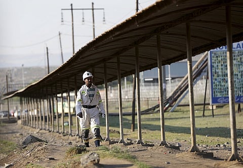 A mine worker returns from the Lonmin mine at the end of his shift, outside Rustenburg October 5, 2015. Platinum producer Lonmin priced its $407 million rights issue at a 94 percent discount as the firm fights for survival in the face of depressed commodity prices after writing down $1.8 billion in assets. Picture taken October 5, 2015. REUTERS/Siphiwe Sibeko