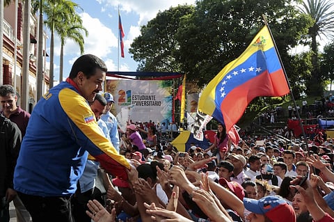 File Photo: Venezuela's President Nicolas Maduro (L) greets supporters during a rally on University Student Day in Caracas, in this handout picture provided by Miraflores Palace. REUTERS/Miraflores Palace