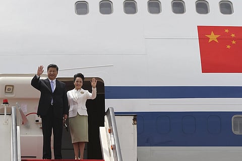 Chinese President Xi Jinping and his wife Peng Liyuan wave as they arrive in Harare, Zimbabwe December 1, 2015. REUTERS/Philimon Bulawayo