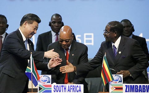 China's President Xi Jinping (L) shakes hands with Zimbabwe's President (R) Robert Mugabe while South Africa's President Jacob Zuma looks on during a Forum on China-Africa Cooperation in Sandton, Johannesburg, December 4, 2015. REUTERS/Siphiwe Sibeko
