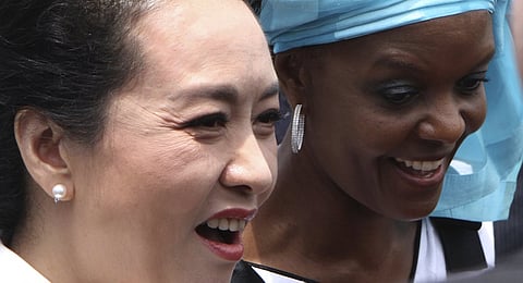 Peng Liyuan, wife of Chinese President Xi Jinping, walks with Grace Mugabe, wife of Zimbabwean President Robert Mugabe, upon arrival in Harare, Zimbabwe. REUTERS/Philimon Bulawayo