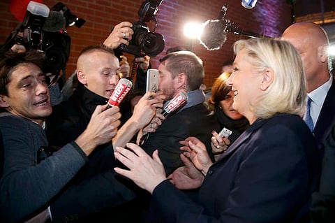 French National Front political party leader and candidate Marine Le Pen is surrounded by media as she leaves after her speech during the first round of the regional elections in Henin-Beaumont, France, December 6, 2015.        REUTERS/Pascal Rossignol