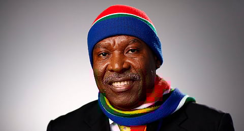 Lesetja Kganyago, governor of South Africa's reserve bank, poses for a photograph wearing a South African coloured matching woollen hat and scarf in Davos, Switzerland. Photographer: Simon Dawson/Bloomberg