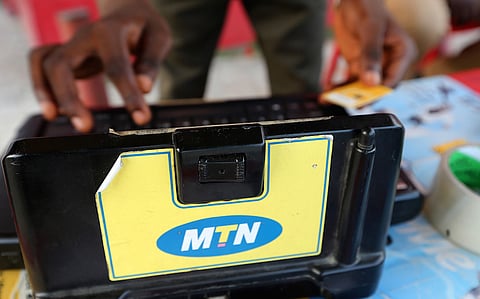 A man enters a customer's mobile phone sim card details on an MTN Group Ltd. registration machine at a roadside kiosk in Lagos, Nigeria, on Saturday, Oct. 31, 2015. Photographer: George Osodi/Bloomberg