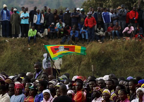 Supporters of Zimbabwe's President Robert Mugabe hold a flag as they attend a rally in Bindura, north of the capital Harare, Zimbabwe July 8, 2016. REUTERS/Philimon Bulawayo