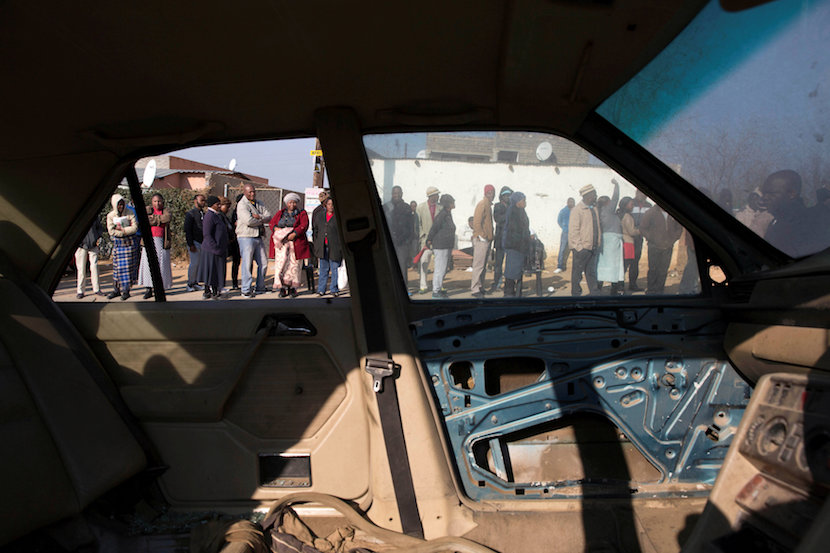 Locals are seen trough a wreck of a car as they prepare to cast their votes during the local government elections in Diepsloot township, South Africa August 3,2016. REUTERS/James Oatway