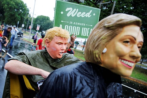 Protesters wearing masks of presidential candidates Hillary Clinton and Donald Trump march with a group of cannabis advocates down Broad Street toward the Wells Fargo Center on the final day of the Democratic National Convention in Philadelphia. REUTERS/Dominick Reuter