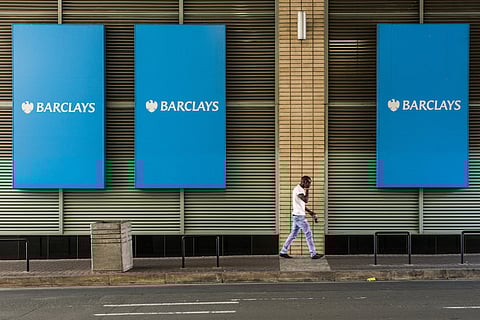 A pedestrian passes large branded signs outside the offices of Barclays Plc bank in Johannesburg, South Africa, on Wednesday, March 2, 2016. The South African Reserve Bank said it will collaborate with Barclays Plc to manage the flow of money and minimize risk of causing fluctuations in the rand as the British bank prepares to reduce its stake in Barclays Africa Group Ltd. Photographer: Waldo Swiegers/Bloomberg
