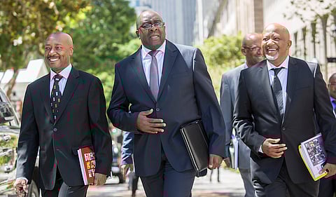 Happier times. Nhlanhla Nene, South Africa's finance minister, center, arrives at parliament to deliver his 2015 budget speech. SARS head Tom Moyane (L) and Deputy FinMin Mcebisi Jonas (R) accompany him. Photographer: Halden Krog/Bloomberg