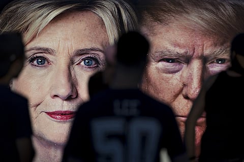 A group of Hofstra University students stand in front of a CNN trailer with images of Hillary Clinton, 2016 Democratic presidential nominee, and Donald Trump, 2016 Republican presidential nominee, ahead of the first U.S. presidential debate at Hofstra University in Hempstead, New York, U.S., on Sunday, Sept. 25, 2016. Clinton and Trump will face each other, and likely a record television audience, in the first general election debate of the 2016 U.S. presidential campaign on Monday. Photographer: Andrew Harrer/Bloomberg
