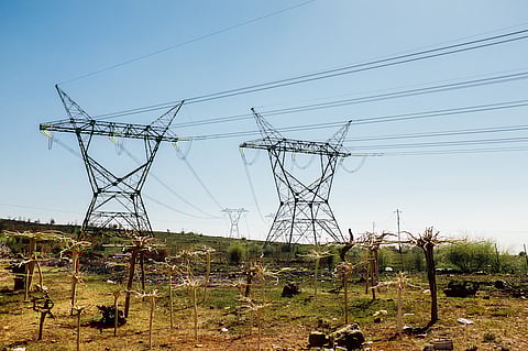 Pylon towers carry electrical power lines across open land in Johannesburg, South Africa, on Thursday, Oct. 6, 2016. Eskom Holdings SOC Ltd. is building new electricity stations to end the power cuts that were imposed for about 100 days last year, curbing growth in Africa's most-industrialized nation. Photographer: Waldo Swiegers/Bloomberg