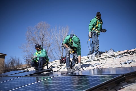 Workers secure solar panels to a rooftop during a SolarCity Corp. residential installation in Albuquerque, New Mexico, U.S. Photographer: Sergio Flores/Bloomberg