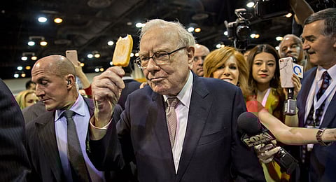 Warren Buffett, chairman of Berkshire Hathaway, Inc., eats a ice-cream bar from Dairy Queen Stores Inc. as he tours the exhibit floor ahead of the Berkshire Hathaway annual meeting in Omaha, Nebraska, U.S., on Saturday, May 6, 2017. Buffett said during the Berkshire investors gathering that he's more inclined than usual this year to sell some assets because the tax advantage could soon diminish for divesting securities at a loss. Photographer: Daniel Acker/Bloomberg